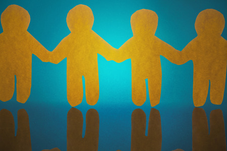 4 yellow paper person holding hands against blue background
