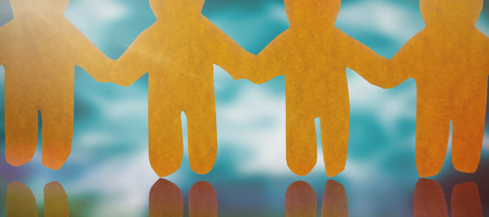 4 yellow paper person holding hands against abstract pattern on wall
