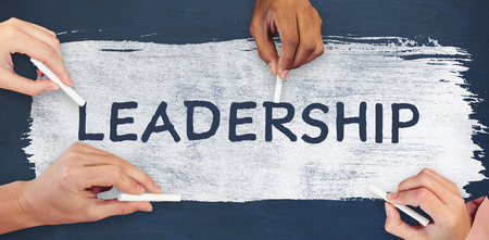 Cropped hands holding chalks against digital composite image of leadership textの写真素材