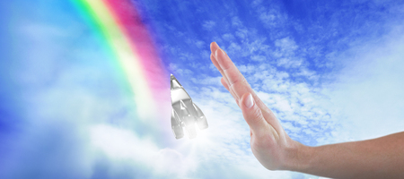 Hand of man pretending to touch invisible screen against idyllic view of cloudscape against skyの写真素材