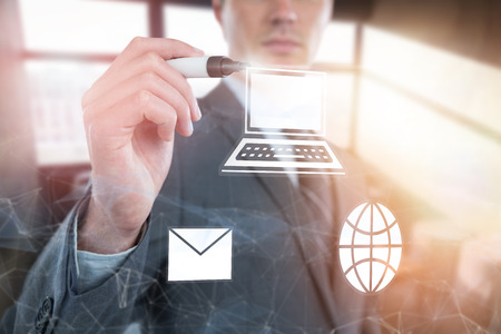 Businessman writing with marker invisible screen  against carefree businessman sitting on sofaの写真素材