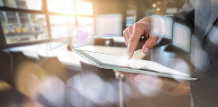 Mid section of businessman using tablet against defocused image of illuminated lighting equipmentの写真素材