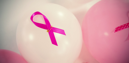 High angle view of pink Breast Cancer ribbons on balloons against white backgroundの写真素材