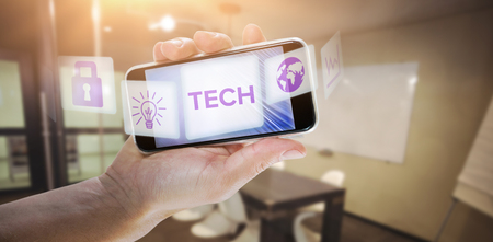 Close-up of cropped hand holding phone against glowing backgroundの写真素材