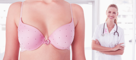 Mid section of woman wearing pink bra for breast cancer social issue against confident female doctor smiling at cameraの写真素材