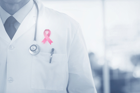 Doctor wearing lab coat  against breast cancer awareness ribbonの写真素材