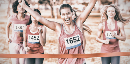 Portrait of cheering brunette winning breast cancer marathon in parklandの写真素材