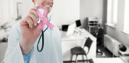 Doctor examining with stethoscope against consultation roomの写真素材