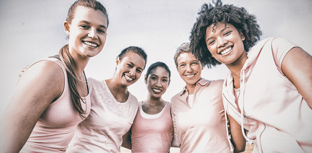 Portrait of smiling women wearing pink for breast cancer at park