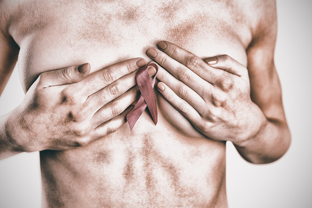 Naked woman with pink ribbon covering breast on white backgroundの写真素材