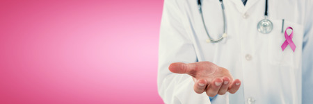 Midsection of doctor gesturing against pink backgroundの写真素材