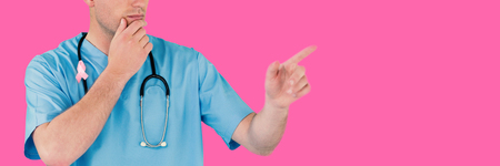 Surgeon pretending to be using futuristic digital screen against pink backgroundの写真素材