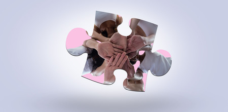 Women in a circle putting their hands together against pastel blueの写真素材