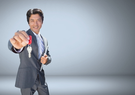 Digital composite of Businessman Holding key in front of vignetteの写真素材