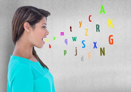 Digital composite of young woman speaking with colour letters coming up from mouthの写真素材