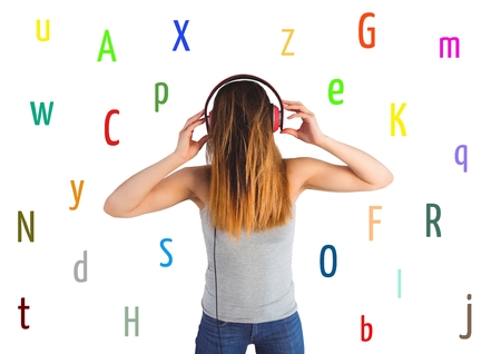 Digital composite of young woman listening music with colour letters around. White back.の写真素材