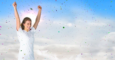 Digital composite of Woman cheering against sunny sky and confettiの写真素材