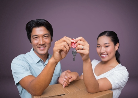 Digital composite of Couple Holding key in front of vignetteの写真素材
