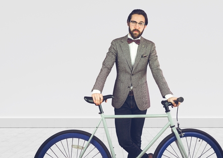 Digital composite of Millennial man in suit with bike against white wallの写真素材