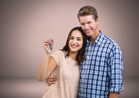 Digital composite of Couple Holding key in front of vignetteの写真素材