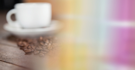 Digital composite of White coffee cup with beans and blurry rainbow transitionの写真素材