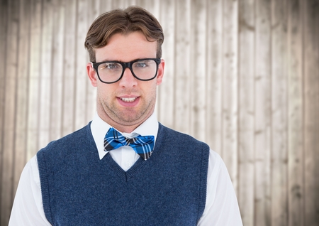 Digital composite of Nerd man in blue vest against blurry wood panelの写真素材