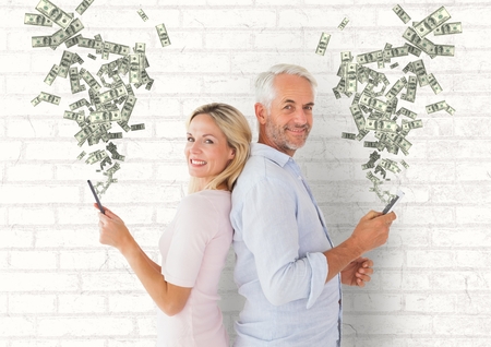 Digital composite of texting money. Senior couple with phones. Money coming up from phonesの写真素材