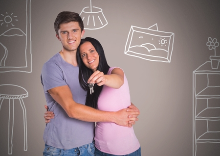 Digital composite of Couple Holding key with home room drawings in front of vignetteの写真素材