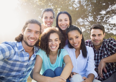 Digital composite of Group of friends smiling in blurry park