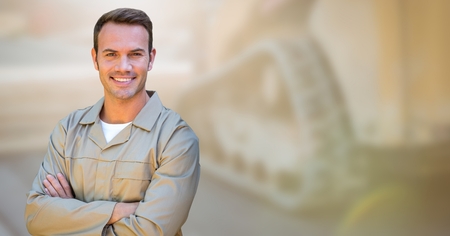 Digital composite of Delivery man arms folded against blurry machineryの写真素材