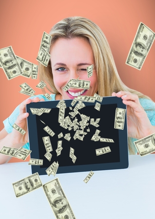 Digital composite of texting money. Happy woman with tablet, money coming up from tabletの写真素材