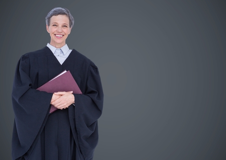 Digital composite of Female judge with book against grey wallの写真素材