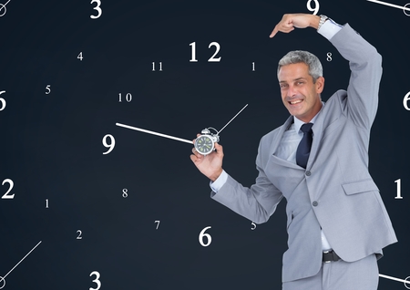 Digital composite of Business man holding a clock against background with clocksの写真素材