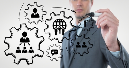 Digital composite of Business man interacting with people in cogs graphics against white backgroundの写真素材