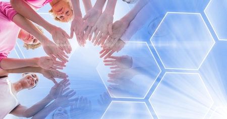 Digital composite of Breast cancer awareness women putting hands togetherの写真素材