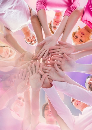 Digital composite of Breast cancer awareness women putting hands togetherの写真素材