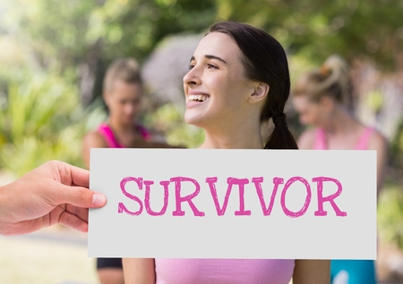 Digital composite of Survivor Text and Hand holding card with pink breast cancer awareness womenの写真素材