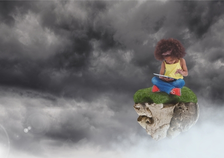 Digital composite of Young Girl on floating rock platform  in sky with tabletの写真素材