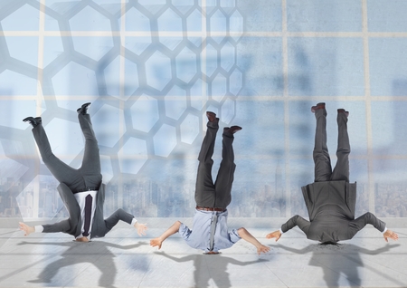Digital composite of 3 business people stuck upside down with transition backgroundの写真素材