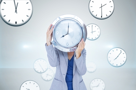 Digital composite of Business woman holding a clock against background with clocks