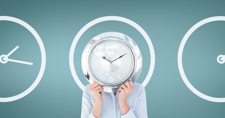 Digital composite of Business woman holding a clock against background with clocksの写真素材