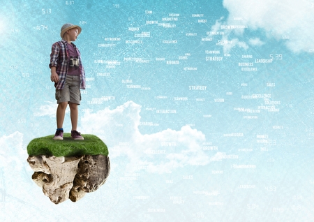 Digital composite of Young adventurer boy on floating rock platform  in sky with word connectors interfaceの写真素材