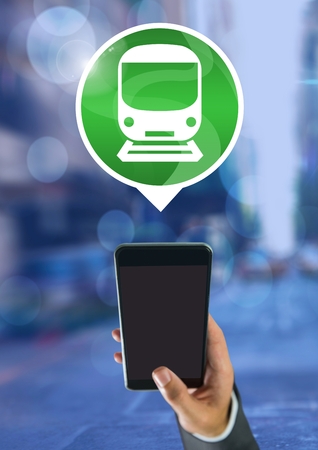 Digital composite of Hand holding phone with train icon in cityの写真素材