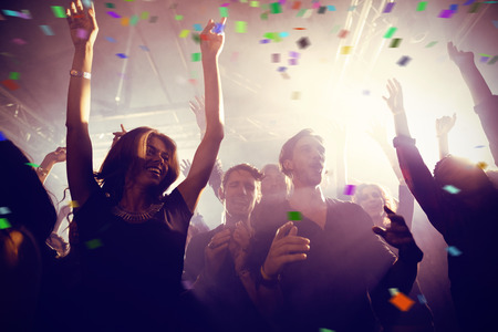 Flying colours against happy people dancing at nightclubの写真素材