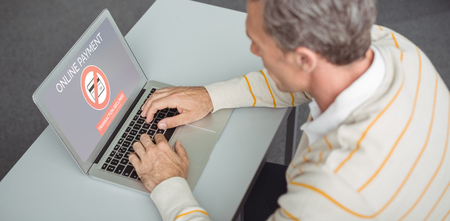 Online payment text on gray display against attentive school teacher using laptop in libraryの写真素材