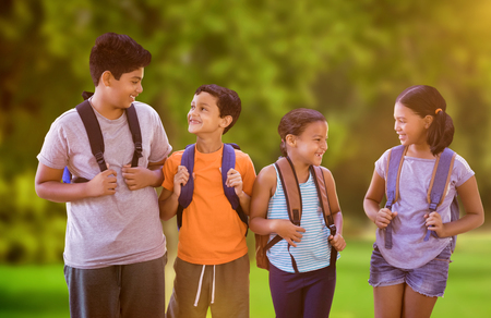 Happy students against white background against trees and meadowの写真素材