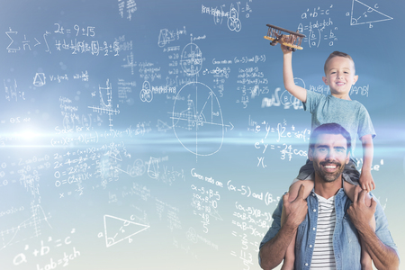 Portrait of father carrying son on shoulders against blue and yellow skyの写真素材