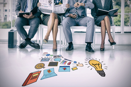 Business people waiting to be called into interview against composite image of various icons by light bulb on white backgroundの写真素材