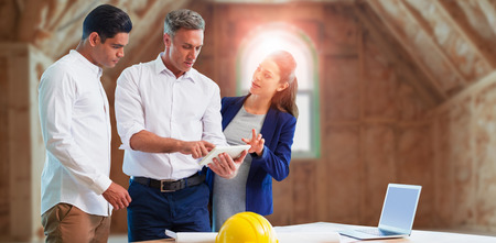 Architect discussing over tablet computer against room in house construction siteの写真素材