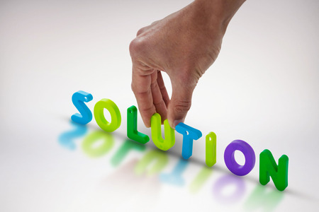 Cropped hand of businessman arranging solution word against grey background